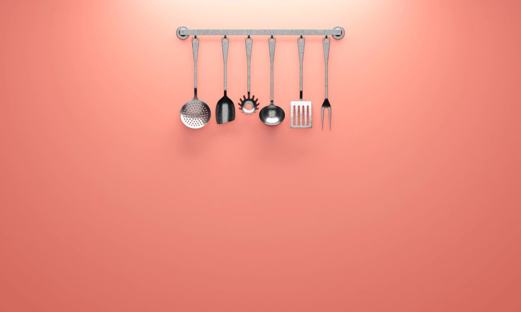 Ustensiles de cuisine suspendus à une barre murale au-dessus du plan de travail
