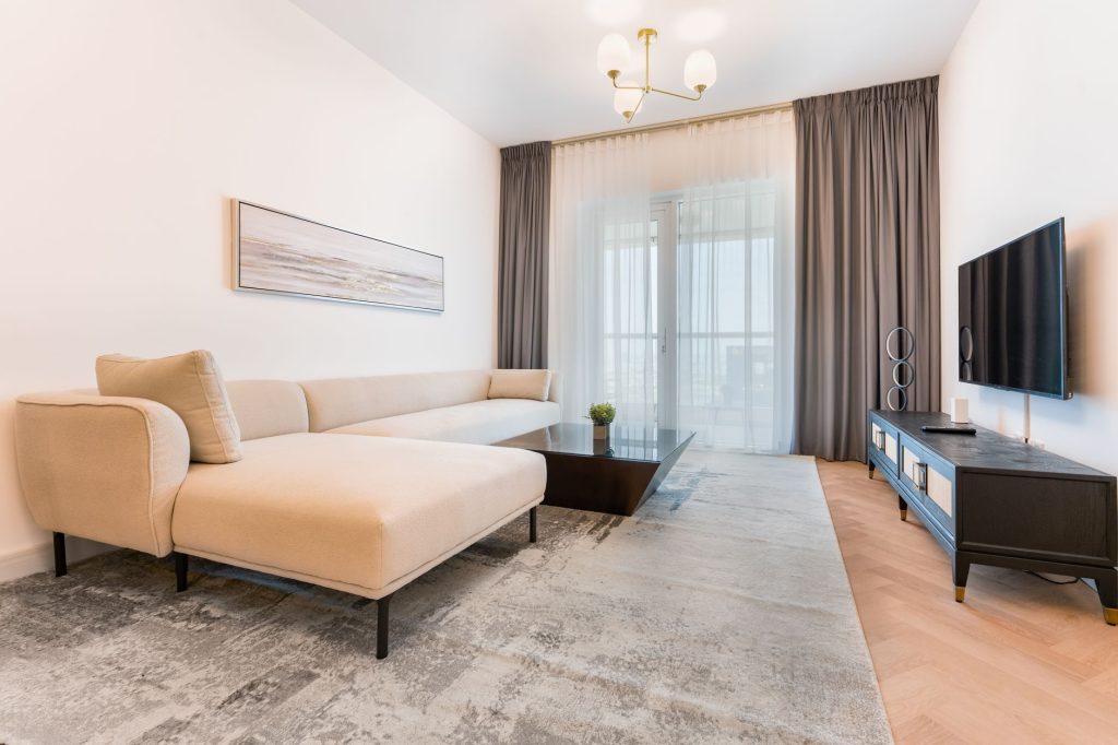 Salon aux tons clairs avec tapis et belle lumière naturelle