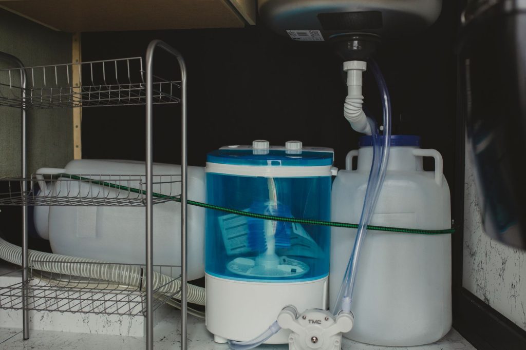 Tuyau et siphon en PVC sous un évier de cuisine