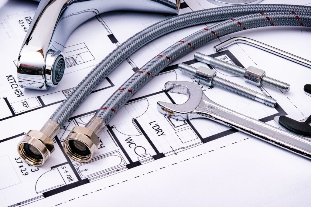Clé à molette et outils de plomberie posés sur un plan de travail