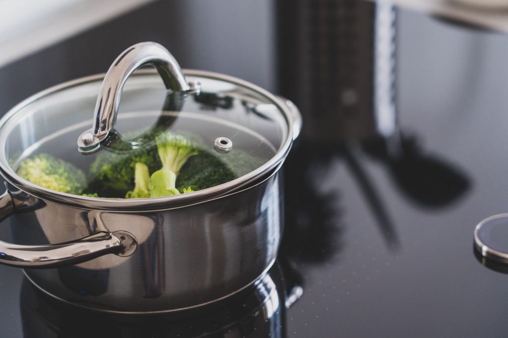 Légumes verts plongés dans une casserole d'eau bouillante pour le blanchiment