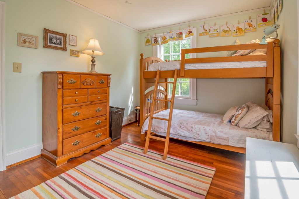 Chambre d'enfant avec lit bas en bois et fond mural neutre