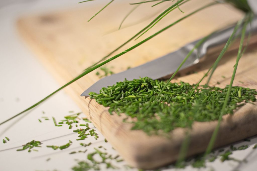 Ciboulette fraiche coupee sur une planche a decouper en bois