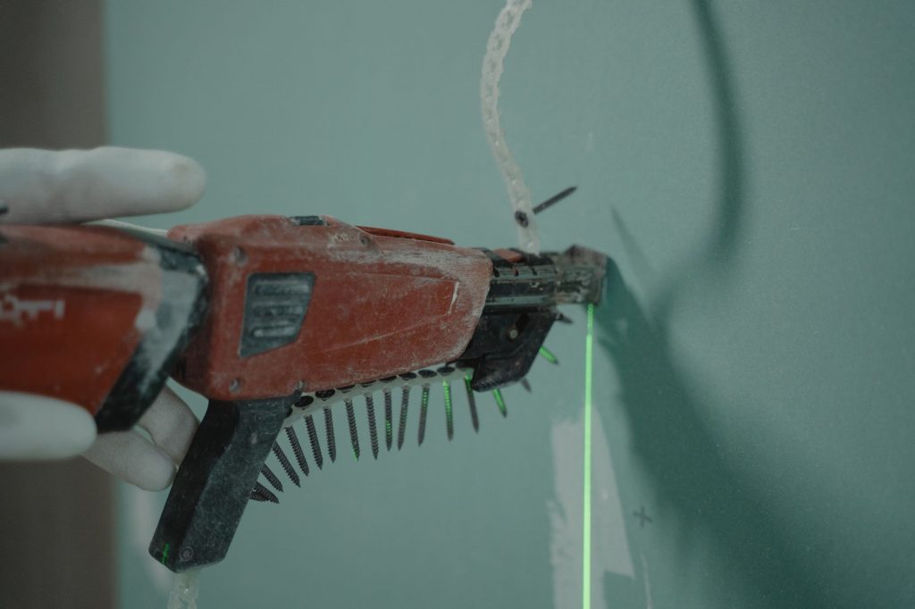 Perçage d’un mur dur en béton avec une perceuse à percussion et de la poussière