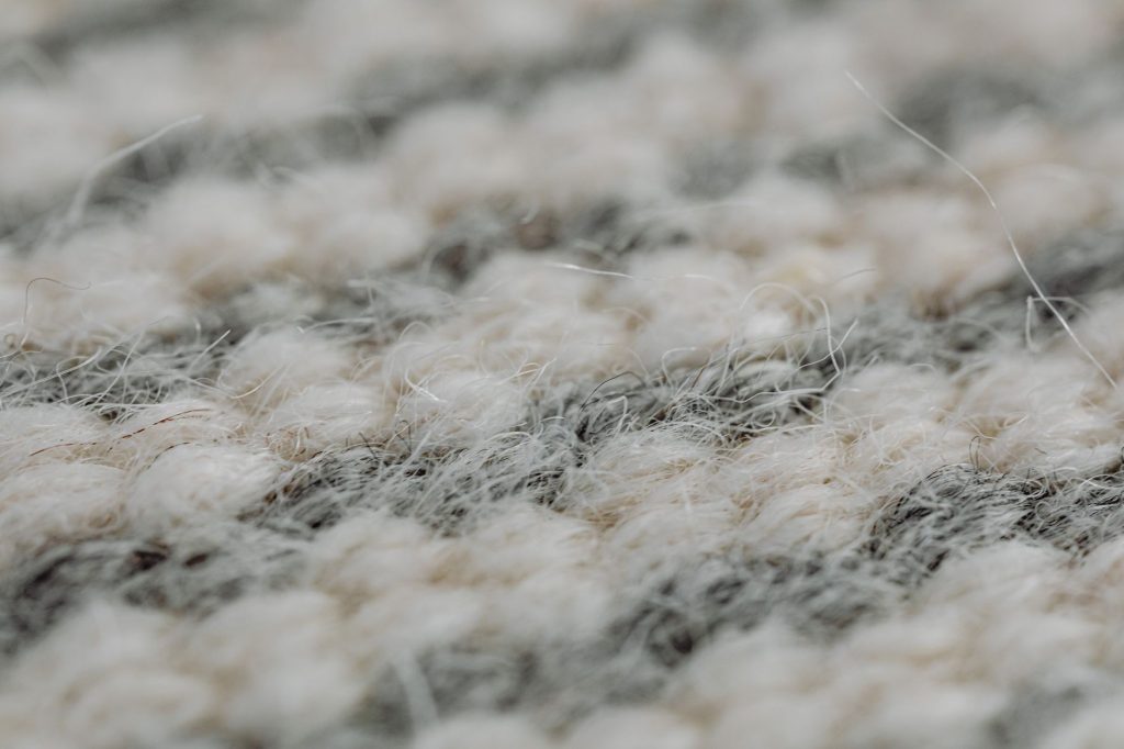 Gros plan sur les fibres d un tapis en laine tissé