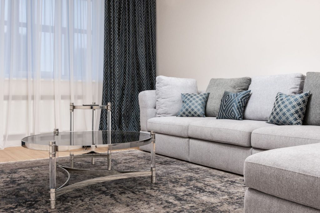 Grand tapis posé sous un canapé dans un salon clair
