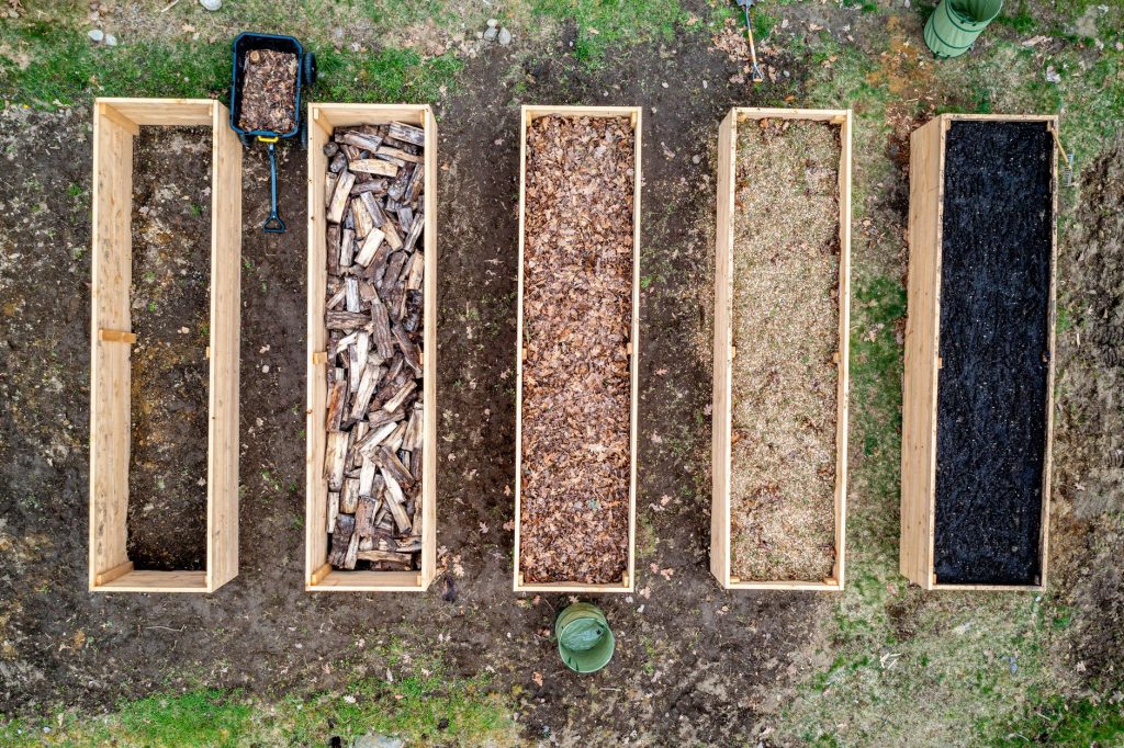 Carré potager en bois en cours de montage dans un jardin