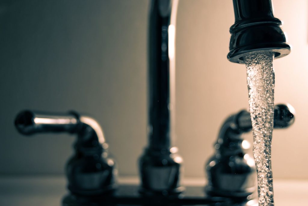 Robinet de cuisine en gros plan avec une goutte d'eau au bout du bec