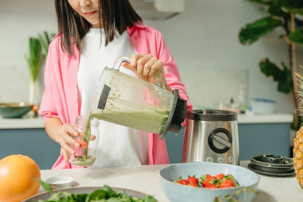 Remplissage d'un bocal en verre avec des légumes préparés sur un plan de travail