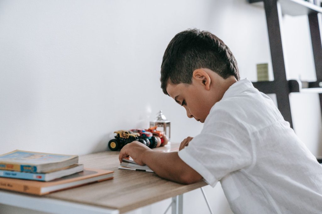 Enfant assis a un bureau pour faire ses devoirs dans sa chambre