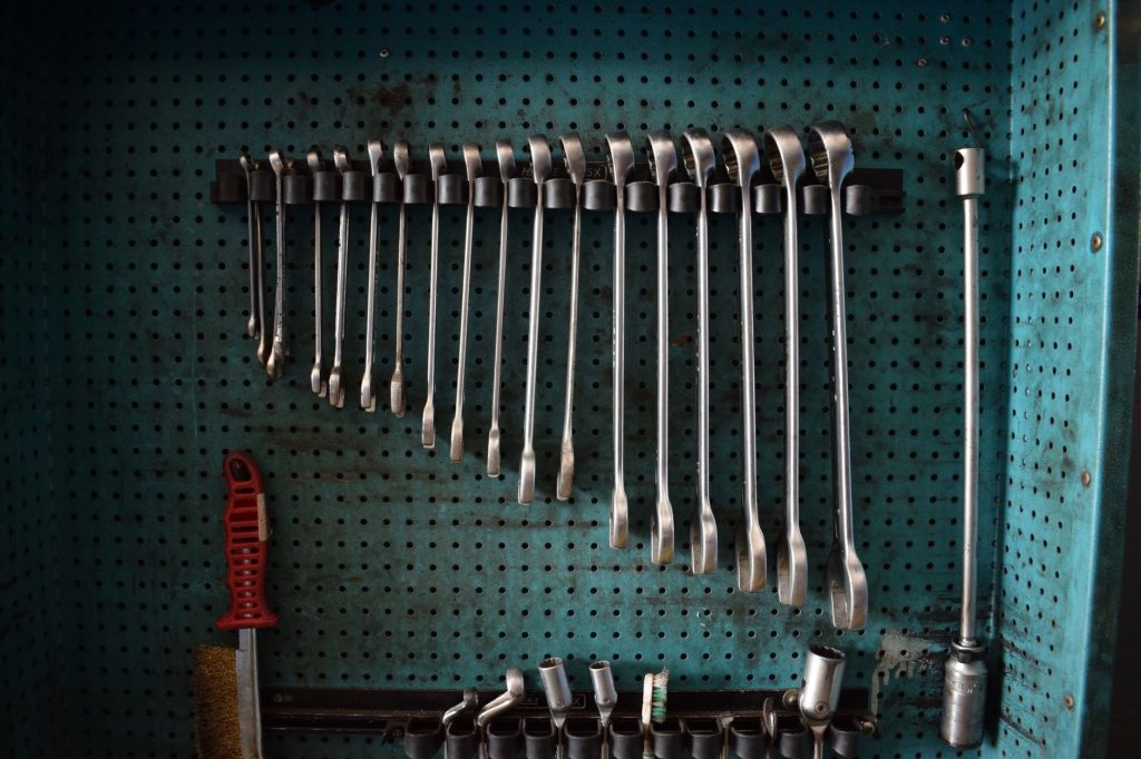 Panneau perfore avec outils de bricolage ranges au mur du garage