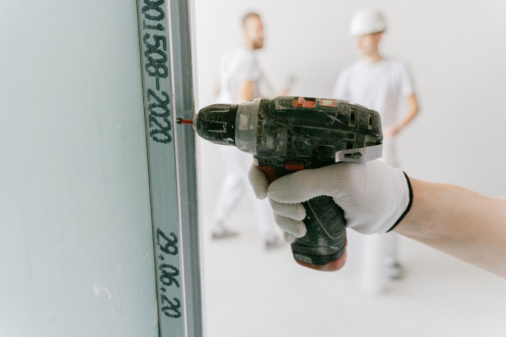 Perçage d'un mur à la perceuse-visseuse pour poser une fixation d'étagère