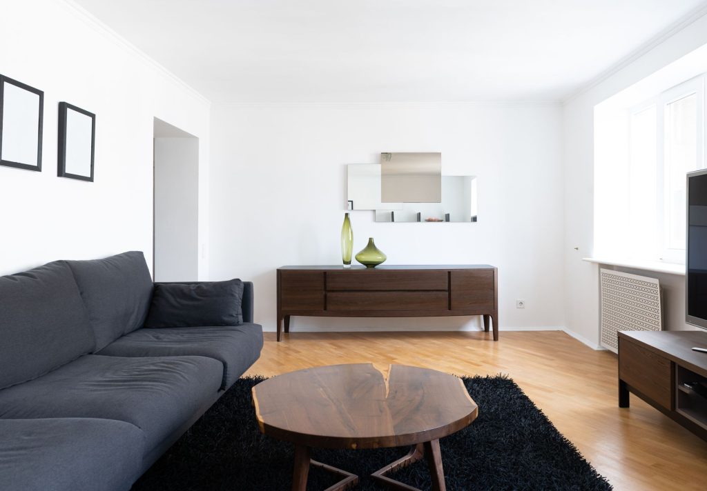 Petit salon lumineux avec miroir et teintes claires dans un studio